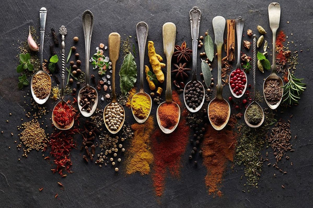 A vibrant collection of assorted spices on a wooden surface.